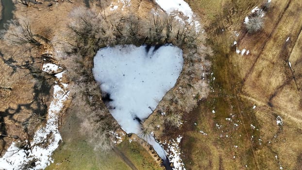 Aerial drone shot of frozen lake with heart shape in bavaria
