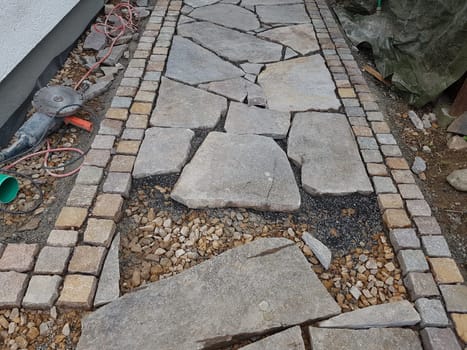 Garden path,made of porphyry slabs and cobblestones under construction. Garden path,made of porphyry slabs and cobblestones under construction