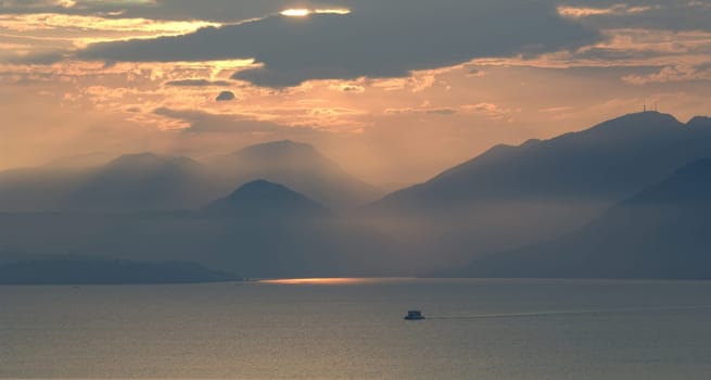Sunset,evening atmosphere on Lake Garda with sailing boats on the water. Sunset,evening mood at Lake Garda with sailing boats on the water.