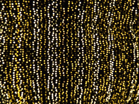 Hanging garlands against the background of the night sky. Festive decoration of city streets. Garlands of yellow, white and gold lights and bulbs. Beautiful background for New Year, Christmas holiday