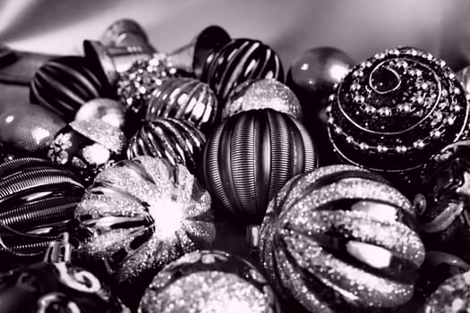Christmas flat lay with Xmas decorations and holiday beautiful balls. Christmas tinsel. Happy New Year and Merry Christmas. Black and white monochrome photo with lilac filter. Still life background.