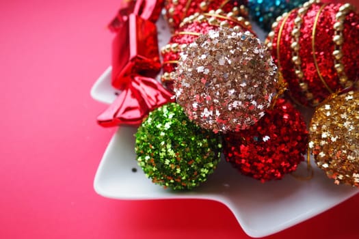 Christmas background with Christmas decorations, holiday balls, bells, bows, fir cone, Christmas tree rain. Happy New Year and Merry Christmas. Red, brown, striped, green, gold, purple, colorful decor