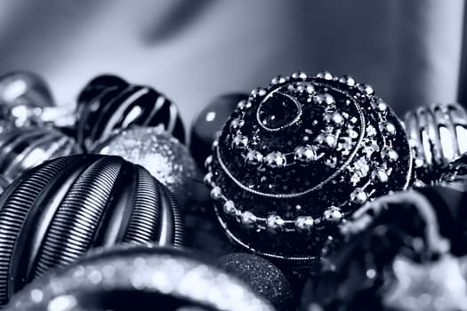 Christmas flat lay with Xmas decorations and holiday beautiful balls. Christmas tinsel. Happy New Year and Merry Christmas. Black and white monochrome photo with blue filter. Still life background.
