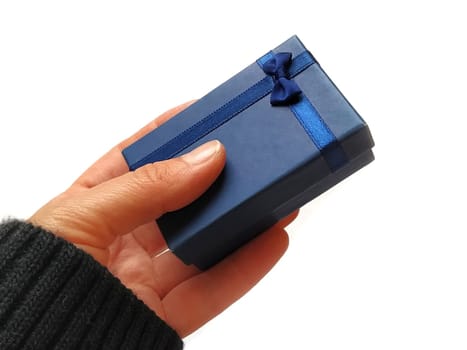Gift box with a blue bow in hand. White background. Gift for New Year, March 8, birthday, Christmas, mother's day or Valentine's day. Black sleeve edge.