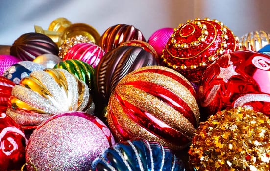 Christmas decorations. Beautiful red, golden, yellow balls with sparkles and stripes. Preparing for the New Year and Christmas holidays. Beautiful decorations. Flat lay and still life. Modern style