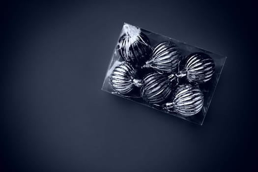 Box with Christmas tree decorations. Gift or purchase. Happy New Year and Merry Christmas. Shiny balls in a package. Black and white monochrome photo with vignetting