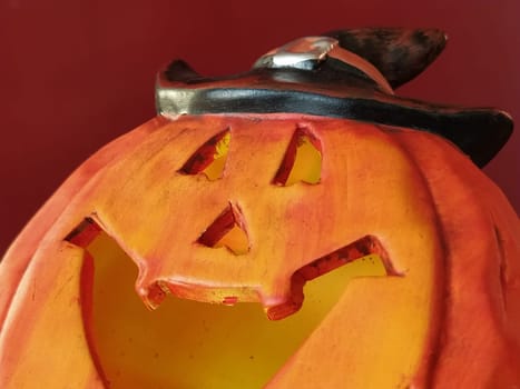 Bright orange Halloween pumpkin. Cut holes for mouth, nose and eyes. Close-up. The sinister laugh of the monster. Blurred.