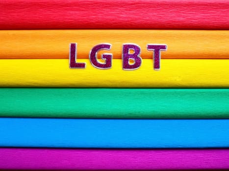 Abbreviation LGBT, letter text. Purple LGBT lettering on the background of the rainbow flag. A Rainbow Flag, the Pride Flag. LGBTQ community symbol. EuroPride 2022.