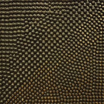 Pimples or spikes made of black and gold metal. Metal rounded bulges are located randomly. Unusual abstract background
