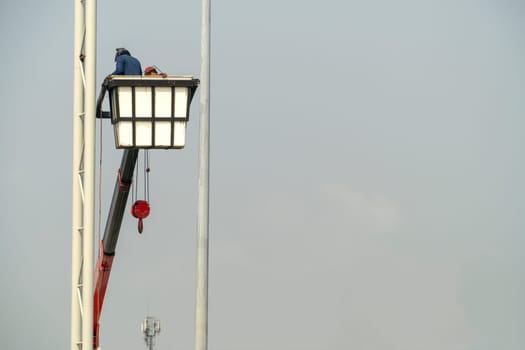 Use crane to lift the light bulbs to repair the light pole