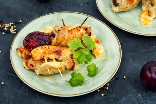 Appetizing meat rolls baked with plum filling on a plate
