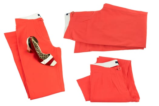 Collage woman clothes. Set of folded red elegant women trousers or denim pants with a matching of elegant single female high heeled shoe. Red fashion concept isolated.