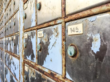 Old rusty metal mailboxes. Shallow depth of field.