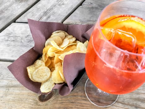 Spritz Aperol with chips, for a perfect pre-dinner. Classic Italian aperitif.