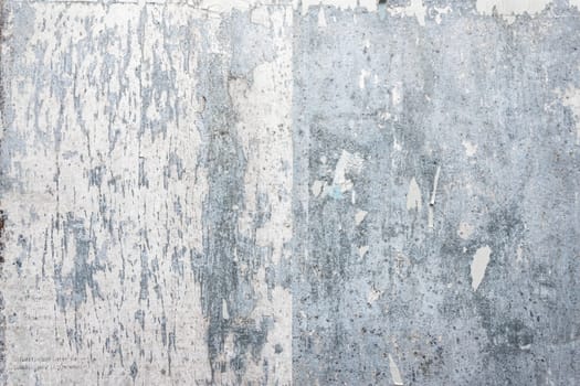 Grunge ripped poster background - texture of torn advertisement on an old rusty billboard panel.