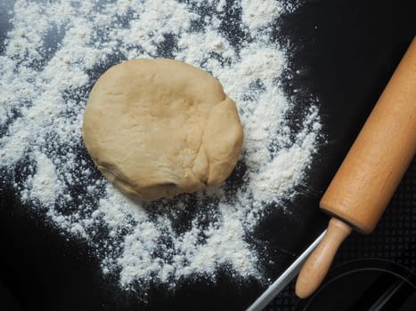 Fresh yeast dough with flour on a kitchen countertop