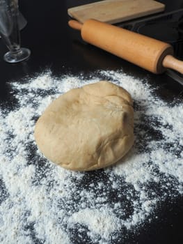 Fresh yeast dough with flour on a kitchen countertop