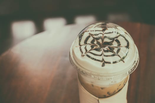 Ice coffee on old wooden table.