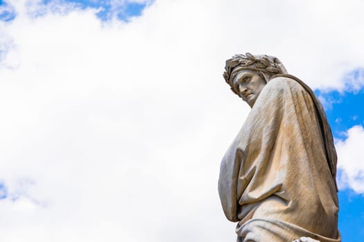 Dante Alighieri statue in Florence, Tuscany region, Italy, with an amazing blue sky background.