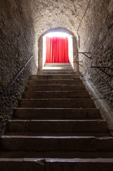 Old corridor with red curtain at the end. Concept for mystery, gothic, escape, hope