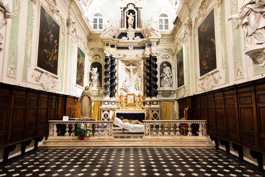 Ventimiglia, Italy - August 2022: the baroque church interior of Oratorio dei Neri with Jesus Christ statue