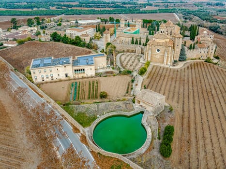 Monastery of Santa Maria de Poblet, Catalonia, Spain, General aerial view taken from the irrigation pond with the detail of Poblet written in white stone