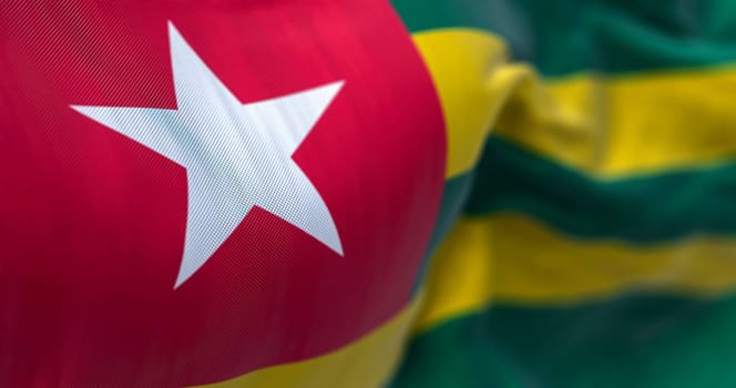 Close-up view of the Togo national flag waving in the wind. The Togolese Republic is a country in West Africa. Fabric textured background. Selective focus. 3d illustration