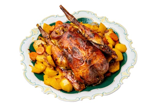 Grilled whole guinea fowl or baked pearl chicken on roasted potatoes and vegetables and port wine sauce is served on a beautiful plate. Clipping path. Isolated on white.