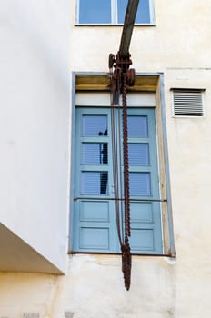 one old pulley with a rusty chain ready to lift