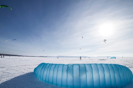 Kite surfer being pulled by his kite across the snow