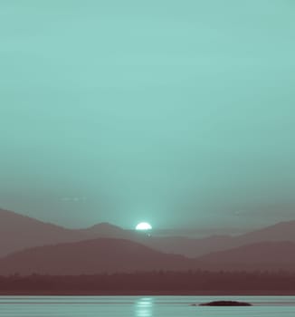 Beautiful sunset over the mountain with reflection on lake