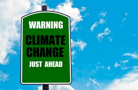 Warning Climate Change Just Ahead written on green road sign  against clear blue sky background. Concept image with available copy space