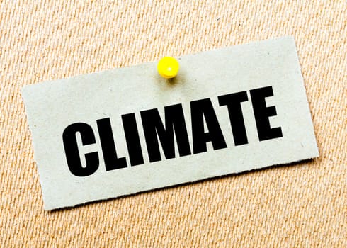Recycled paper note pinned on cork board with word CLIMATE. Concept Image