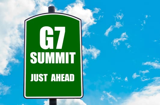 G7 SUMMIT Just Ahead written on green road sign  against clear blue sky background. Concept image with available copy space
