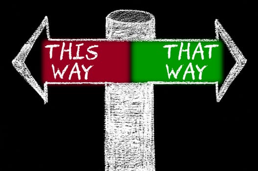 Opposite arrows with This Way versus That Way. Hand drawing with chalk on blackboard. Choice conceptual image