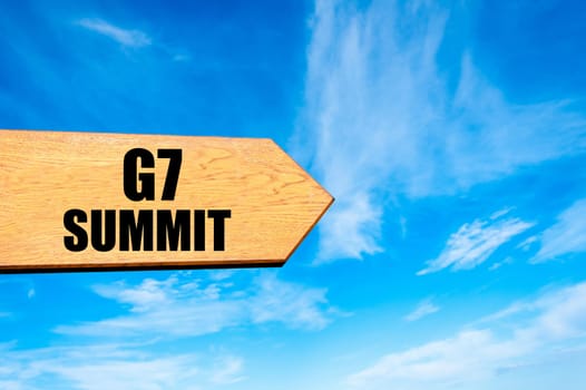 Wooden arrow sign pointing destination  G7 SUMMIT against clear blue sky with copy space available. Travel destination concept  image