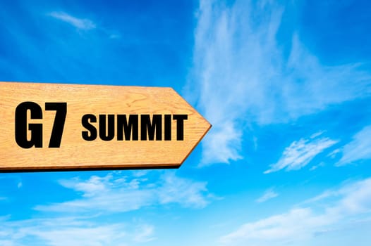 Wooden arrow sign pointing destination  G7 SUMMIT against clear blue sky with copy space available. Travel destination concept  image