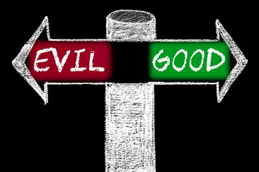 Opposite arrows with Evil versus Good. Hand drawing with chalk on blackboard. Choice conceptual image
