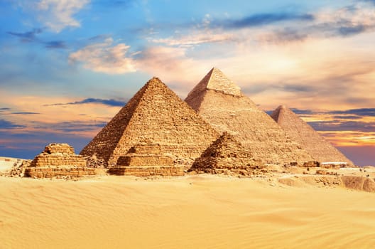 The Great Pyramids of Giza under a colorful desert sky, Egypt.