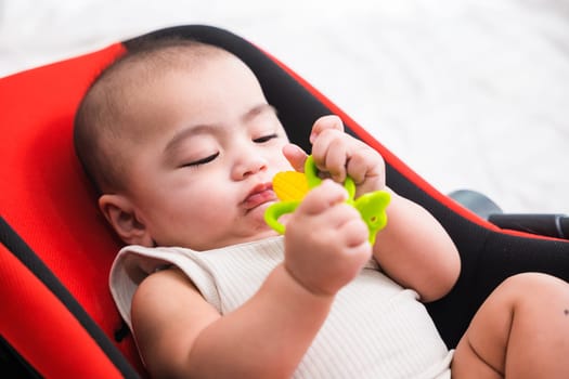Portrait of Asian infant child on bed and playing, Baby boy lying at home, Childcare healthy