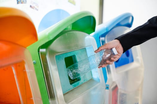 World Environment Day concept. Business woman throwing empty plastic bottle water into recycle garbage trash or bin, Waste management environmental recycling concept