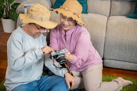 Travel and tourism. Asian couple old senior marry retired couple smiling taking photo by camera during luggage suitcase arranging for travel, Happy mature retired couple photography weekend holiday