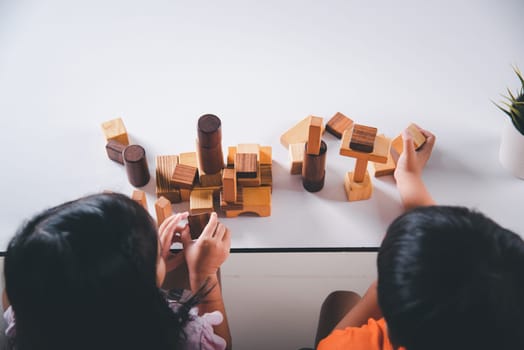 Children boy and girl playing with constructor wooden block building, Happy little kids play wood block stacking board game at home, activities learning creative, toys for preschool and kindergarten