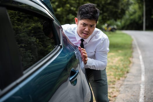 Asian businessman car broken has problems with car down during go to work in morning he pushing out of gas on road at countryside, business man have trouble roadside, problem transportation