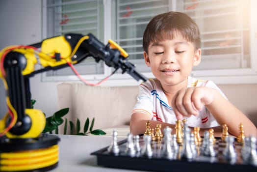 Asian little boy is playing chess with robot machine arm, STEM education E-learning, Funny children learning successful getting a lesson control robot arm, Technology science education concept