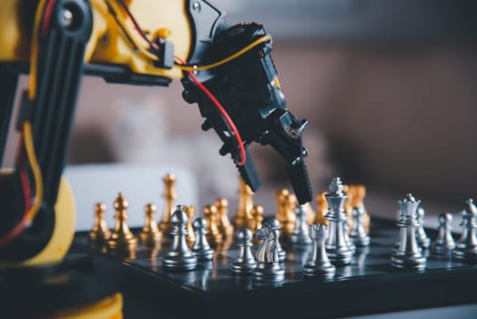 Closeup yellow robot arm playing move chess on chessboard, STEM education E-learning, Technology science robot education concept