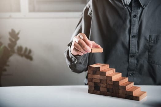 Business hand arranging put wooden block stacking step stair growth success process, financial risk management and strategic plan and business challenge planning concept, prevent collapse or crash