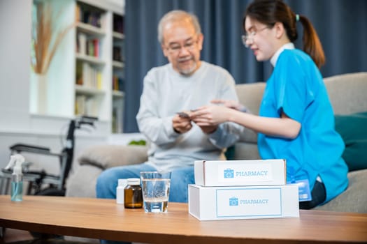 Woman nurse caregiver showing prescription drug to senior man at nursing home, healthcare support, Asian doctor with physician visit senior male patient consult medicine dosage at house in living room