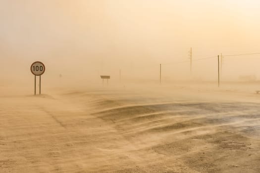 Sandstorm covering the road from Swakopmund to Walvis Bay in Namibia in Africa.