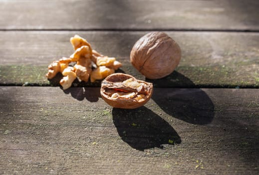 Walnuts over wooden picnic table. Natural light shot